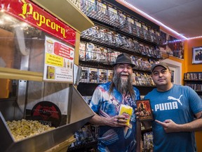 From left, Bill Lucas and Nigel Hartwell, the new owners of Jumbo Video located on 318 Front Street in Belleville, stand alongside a popcorn machine in their store on Friday. ALEX FILIPE