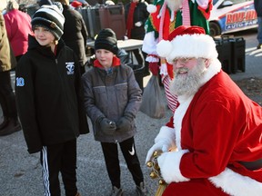 Travis and Drew meet with Santa Claus while they wait for the arrival of the Canadian Pacific Holiday Train in Chatham Dec. 1, 2022. (Tom Morrison/Postmedia Network)