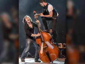 Sam Weber leaps onto his brother Ryan's double bass as the duo perform onstage. Image taken by Donna Hopper