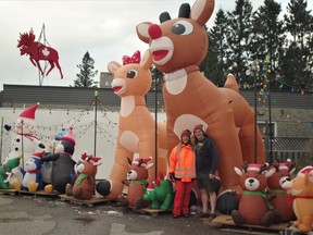 Martha Jacobs and Tim Hainsworth with their Rudolph and Clarice reindeer blow-ups. Each season the couple put up about 50 Christmas-themed floats in the parking lot of their Corner Wines shop in South River.
