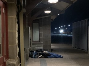 Two homeless individuals lay on the ground outside the North Bay Museum Friday night. Boots on the Ground volunteers provided a coat, mitts and snack packs to them. Volunteers are frustrated with the lack of resources available to help those struggling.