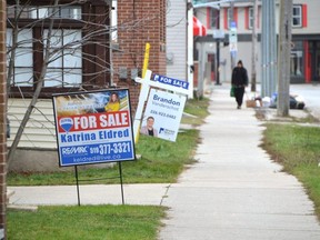 Real estate signs on the front lawns of homes along 3rd Avenue East in Owen Sound on Friday, December 9, 2022.