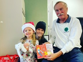 Three-year-old Millie Moran and her mother Beth gave new books to Literacy Lambton volunteer and former board chair Steve Anema as part of Literacy Lambton's Give-A-Book campaign.  Millie donated to several organizations during the holiday season in tribute to her late grandfather and uncle.  Handout/Sarnia This Week