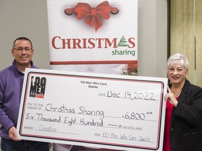 Jae Cheyne, left, member of 100 Men Who Care Quinte, presents the group's first instalment of their $8,400 donation to Hazel Lloyst, coordinator at the Christmas Sharing Program, on Wednesday in Belleville, Ontario. ALEX FILIPE