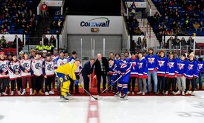 Roberts Lefevrs/Hockey Canada Images Zviedru kapteinis Aksels Lendens un amerikāņu kapteinis Kols Nobls uzņemas ceremoniju, kurā piedalās Colts īpašnieks/galvenais treneris Ians Makinss un bijušais īpašnieks Allagars Pasaules junioru sērijā. , 2022. Colts 30. gadadiena tika atzīmēta ar Jr. A un AAA komandu dalībniekiem pirms spēles sākuma, kurā ASV uzvarēja ar 3:0.