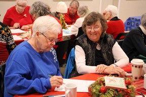 Ann Finlayson, kiri, dan Mary Anne Kukoly bekerja sama dalam kegiatan kata Natal di makan siang Natal Ripley dan District Horticultural Society 30 November. Foto oleh Christine Roberts.