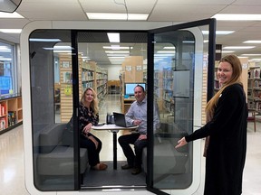 Tiffany Gartner-Duff, engagement and partnerships specialist with Chatham-Kent Ontario Health Team, and Matt Keech, program manager for Chatham-Kent Employment and Social Services, sit inside a new quiet pod at the Chatham-Kent Public Library as Cassey Beauvais, manager of public services for the Chatham-Kent Public Library holds open the door. (Handout/Postmedia Network)