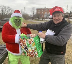 The Grinch (Matt Suckel) and Jim McEachern engage in mock battle over some gifts prior to the second annual Waterford Santa Claus on Saturday.  Both are members of the Waterford Lions Club, who organized the parade.  VINCENT BALL