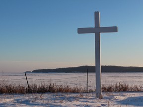A cross outside the Nativity of the Blessed Virgin Roman Catholic Church, which was destroyed in August 2022, overlooks the frozen Lake Athabasca in Fort Chipewyan, Alta. in this December 2014 file photo. Vincent McDermott/Fort McMurray Today/Postmedia Network