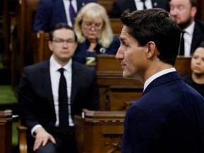 Conservative Leader Pierre Poilievre (background) watches Prime Minister Justin Trudeau speak in the House of Commons. Blair Gable/REUTERS