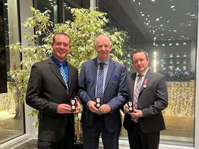 Mayor Jeff Acker (left), his father Joseph Acker (centre), and his brother Jason Acker (right) pose with their Queen Elizabeth II Platinum Jubilee Medals during an award ceremony at the Queen Elizabeth II Building in downtown Edmonton on Thursday, Dec. 8, 2022. Photo by Sophia Acker.
