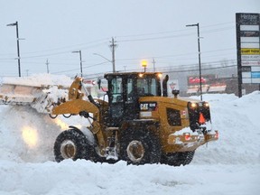 A front-end loader clears snow in the parking lot at Heritage Place Mall in Owen Sound on Monday, December 26, 2022.