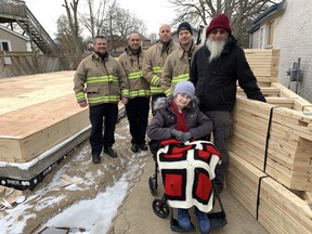 Barb and Dave Gilbert pose in front of the firefighting team of Scott Rattray, left, Gavin Jacklyn, Justin Oakes and Mac Nelson that responded to an explosive house fire at 41 Huron St. on Nov. 3, 2021. Rattray, Oakes and Nelson located Barb Gilbert in the burning house while Jacklyn – who has been part of the Gilbert family circle since childhood – came along later, despite being on vacation.