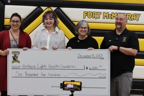 Dan Tulk with a giant cheque for the Northern Lights Health Foundation after he's shaved bald at Fort McMurray Composite School after $13,000 was raised for local charities on December 15, 2022. Photo by Momin Syed/FMPSD