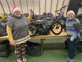 Laura Bowlby (left) and Margaret Knill-Wilson, of the Paris Community Christmas Toy and Hamper program, with a couple of bicycles that will be delivered to a children in Brant County on Christmas morning.  Vincent Ball