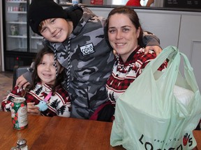 Alicia Doxtator and her children, William, 10, and Alison, 8, get some takeaway on Christmas Day from Honey's Bistro on Brant Avenue.  The newly-opened eatery offered a free holiday meal to the community.  MICHAEL RUBY