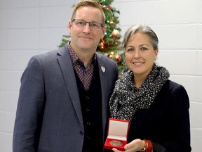 Rob Adams, CEO of the YMCA of Eastern Ontario, presents a Peace Medal Award to Heather Haynes of Kingston on Friday. The area Y honoured Haynes for her longstanding support of children in Goma, Democratic Republic of the Congo.