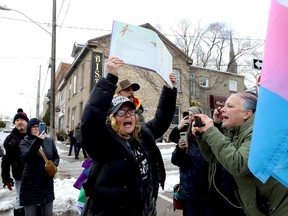 Chrystal Peters holds up a book while protesting against the Brockville Public Library's Drag Storytime event on Saturday afternoon, while Deana Sherif, right, joins the counter-protesters. (RONALD ZAJAC/The Recorder and Times)
