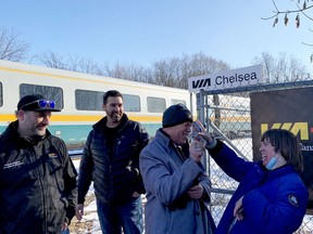Chelsea Cadieux, right, flashes her trademark playing cards with Mike Oliphant while Oliphant's fellow Via Rail engineers Tyson Venne and Dominique Marleau look on as a Via train heads by on Wednesday afternoon in Brockville. (RONALD ZAJAC/The Recorder and Times)
