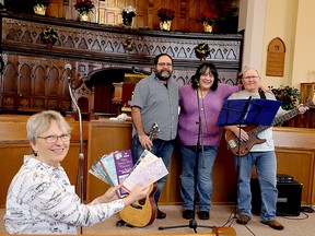 Donna Matheson, foreground, holds a collection of pamphlets from previous years' New Year's Eve concerts, while Ashley Tipper, Natalie Edwards and Paul Edwards pose at First Baptist Church on Wednesday. (RONALD ZAJAC/The Recorder and Times)