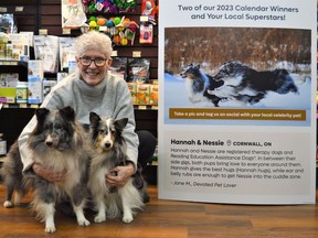 Jane McLaren with Hannah (left) and Nessi (right) at the Eastcourt Mall Pet Valu, with a large display showcasing a winning photo of them, on Monday December 12, 2022 in Cornwall, Ont. Shawna O'Neill/Cornwall Standard-Freeholder/Postmedia Network