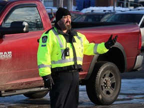 Cornwall Police Service auxiliary Sgt. Jeff Derouchie directing traffic in the civic complex parking lot at the Christmas food hamper and toys distribution event. Photo on Wednesday, December 21, 2022, in Cornwall, Ont. Todd Hambleton/Cornwall Standard-Freeholder/Postmedia Network