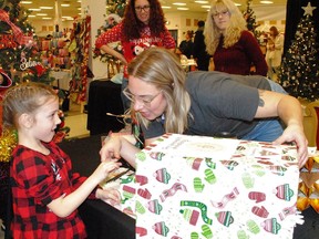 Mia Martell, 5, pulls out a lucky winner for volunteer Meghan Heuvel during the Christmas tree raffle for the Cornwall Community Hospital Foundation, part of the W3G & Co. Christmas Market & Tree Raffle at Cornwall Square on Saturday December 10, 2022 in Cornwall, Ont. Greg Peerenboom/Special to the Cornwall Standard-Freeholder/Postmedia Network