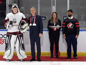 Roberts Lefebvrs/Hockey Canada Images Latvijas vārtsargs Aksels Ozulis saņem Latvijas vēstnieka Kaspara Ozulenca atzinību par spēlētāja atzinību, ko gaida Džastins Taundeila Kornvolas mērs pēc atklāšanas kārtas mača pret Kanādas East World Junioru.  Izaicinājums Cornwall Civic Complex svētdien, 2022. gada 11. decembrī. Kanādas austrumi uzvarēja ar 3:1.