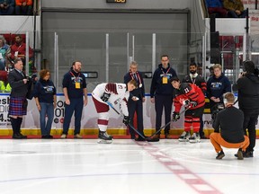 Roberts Lefevrs/Hockey Canada Images Latvijas kapteinis Rodionzs Poltramovičs un Kanādas austrumu kapteinis Trents Kreins svinīgā konfrontācijā ar Latvijas vēstnieku Kasparu Ozulencu un vietējiem augsta ranga pārstāvjiem Pasaules Junioru A izaicinājuma atklāšanas spēlē Kornvolas pilsoniskajā kompleksā Svētdien, 2022. gada 11. decembrī. Austrumi uzvarēja ar 3:1.