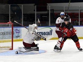 Roberts Lefebvre/Hockey Canada images Latvijas vārtsargs Aksels Ozols svētdien, 2022. gada 11. decembrī, Cornwall Civic Complex notiekošajā World Junior Challenge posmā cīnās pret Patriku Saeni no Kanādas Austrumiem. Kanādas austrumi uzvarēja ar 3:1.