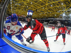 Foto: Roberts Lefebvrs / Kanādas hokejs Skaists skats uz Kanādas austrumos esošo Zaueru Prokopcu, kad viņš trešdien, 2022. gada 14. decembrī, Kornvolas pilsoniskajā kompleksā World Junior A Challenge spēles laikā ved uz dēļiem amerikāņu spēlētāju Raienu Sentluisu. Uzvarēja ASV. 7-2.