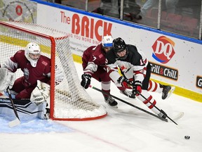 Foto: Roberts Lefebrs/Hokejs Kanāda Kanādas Rietumu spēlētājs Raiders Maters tur savu nūju pie ripas, kad latviešu spēlētājs Toms Mots viņu dzenā Pasaules Junioru izaicinājuma spēles laikā Kornvolas pilsētvides kompleksā trešdien, 2022. gada 14. decembrī. Kanādas rietumi uzvarēja ar 10:0.