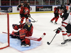 Roberts Lefevrs/Hockey Canada foto Austrumu Kanādas vārtsargs Ītans Morovs izglābj Rietumkanādas kapteini Liamu Vatkinsu Pasaules junioru izaicinājuma laikā. Pirmdien, 2022. gada 12. decembrī, Kornvolas pilsētvides kompleksā A. Kanādas rietumi šajā spēlē uzvarēja ar 6:3.