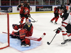 Roberts Lefevrs/Hockey Canada foto Austrumu Kanādas vārtsargs Ītans Morovs izglābj Rietumkanādas kapteini Liamu Vatkinsu Pasaules junioru izaicinājuma laikā.  Pirmdien, 2022. gada 12. decembrī, Kornvolas pilsētvides kompleksā A. Kanādas rietumi šajā spēlē uzvarēja ar 6:3.