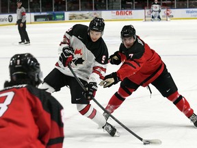 Roberts Lefevrs/Hockey Canada foto Hadsons Malinovskis no Kanādas rietumiem, pa kreisi, ņem momentu, kad Kanādas austrumu spēlētājs Raiens Džonstons izdara spiedienu World Jr. Challenge laikā. A Kornvolas pilsētvides kompleksā pirmdien, 2022. gada 12. decembrī. Kanādas rietumi uzvarēja 6. spēlē. 3.