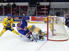 Roberts Lefevrs/Hockey Canada Images Otrdien, 2022. gada 13. decembrī, Kornvolas pilsētvides kompleksā Pasaules junioru A izaicinājuma laikā zviedru vārtsargs Noa Erledens met ciemu, lai bloķētu Gevinu Lindbergu no ASV komandas. ASV uzvarēja spēlē ar 3:0.