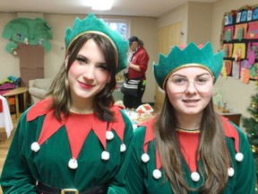 Elves, Jamie Waun, left, and Gwyn Greer, help Saturday at the Point Edward Early Learning Center during the 11th annual Christmas in the Village.