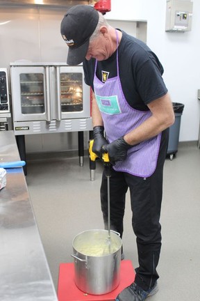Harry Stam uses a drill to whip a big pot of mashed potatoes for the Community Christmas Day Dinner hosted by Church Out Serving at its new community center Riversyde 83 on Sydenham Street in Simcoe.  MICHAEL RUBY