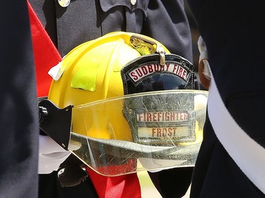 A member of the Greater Sudbury firefighters honour guard holds the helmet of Greater Sudbury firefighter Mike Frost during a funeral procession in downtown Sudbury, Ont. on Wednesday June 1, 2022. John Lappa/Sudbury Star/Postmedia Network