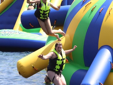 Kristin Ledoux, right, and her daughter, Hailey, 11, jump off an inflatable at the Splash N Go Adventure Parks Limited on Ramsey Lake in Sudbury, Ont. on Monday July 18, 2022. John Lappa/Sudbury Star/Postmedia Network
