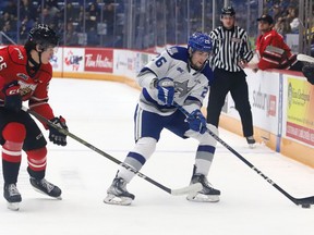 Dylan Robinson, right, of the Sudbury Wolves, attempts to evade Kaleb Lawrence, of the Owen Sound Attack, during OHL action at the Sudbury Community Arena in Sudbury, Ont. on Friday December 2, 2022. John Lappa/Sudbury Star/Postmedia Network