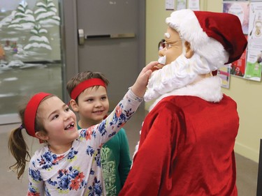 Kindness Ninjas Vienna Chevrier, 6, left, and Ryder Dugas, 4, of Larchwood Public School in Dowling, interact with a Santa Claus statue while visiting Cambrian College students to spread kindness at the campus in Sudbury, Ont. on Wednesday December 7, 2022. More than 40 Kindness Ninjas from junior kindergarten to Grade 2 at Larchwood Public School, visited with Cambrian students studying for exams to spread kindness and cheer during a stressful time for college students. John Lappa/Sudbury Star/Postmedia Network