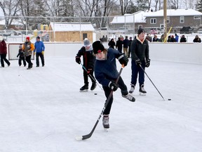 Local youngsters test out the ice during the grand opening of the new outdoor rink at Robinson Playground