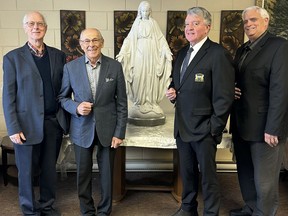 Reg Kusnierczyk and Joe Pintum, members of the charter class at St. Charles College, join Gerry and Geoffrey Lougheed, St. Charles alumni, celebrate the return of a statue of the Holy Mother to the school.