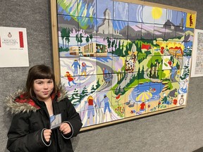 Belleve Peltier, 7, holds the pattern she painted of the McIntyre Headframe onto tile B3 for the community painting of Timmins year-round. It was completed at the Royal Tea Paint Party on July 1, in honour of the Queen's Jubilee. The public painted the 70 small canvases without knowing what the design would be until it was unveiled at "Honouring the Past," the 75th-anniversary show for the Porcupine Art Club. Peltier had been looking forward to seeing the final piece since the summer. "I put a lot of feeling into my work," she said, pleased with the final result. "I think it's incredible."

NICOLE STOFFMAN/The Daily Press