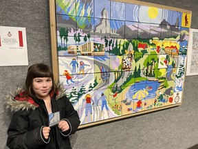 Belleve Peltier, 7, holds the pattern she painted of the McIntyre Headframe onto tile B3 for the community painting of Timmins year-round. It was completed at the Royal Tea Paint Party on July 1, in honour of the Queen's Jubilee. The public painted the 70 small canvases without knowing what the design would be until it was unveiled at "Honouring the Past," the 75th-anniversary show for the Porcupine Art Club. Peltier had been looking forward to seeing the final piece since the summer. "I put a lot of feeling into my work," she said, pleased with the final result. "I think it's incredible." NICOLE STOFFMAN/The Daily Press