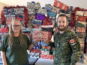Linda Butler and her son Master Corporal William Butler stand in front of some of the 121 Christmas Joy in a Box decorated shoe boxes - filled with goodies - that were shipped to Canadian military troops for Christmas this year. SUBMITTED