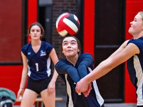 Assumption Lions' Chloe Bomberry (center) and Josie Maclean (right) both reach to return a serve during a high school senior girls volleyball game against the Paris Panthers Thursday in Paris. Brian Thompson/Brantford Expositor/Postmedia Network