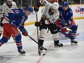 Matthew Papais (20) and Lleyton Moore battle for the puck as the Owen Sound Attack host the Kitchener Rangers inside the Harry Lumley Bayshore Community Centre on Saturday, Dec. 28, 2022. Attack Hockey/Allison Davies