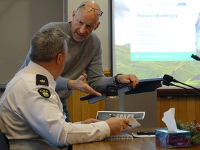 Coun. Bob Bernie during the meeting, talking with OPP Detachment Commander Insp. Jeff Duggan holding onto a preliminary 2020 copy of Kenora's safety and well-being plan.